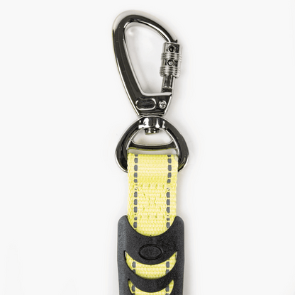 Yellow dog leash with black handle on a white background
